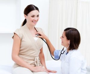 Doctor using a stethoscope on patient