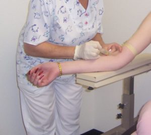Nurse performing blood work on a patient
